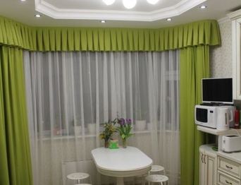 Зелёные шторы и диван на кухне